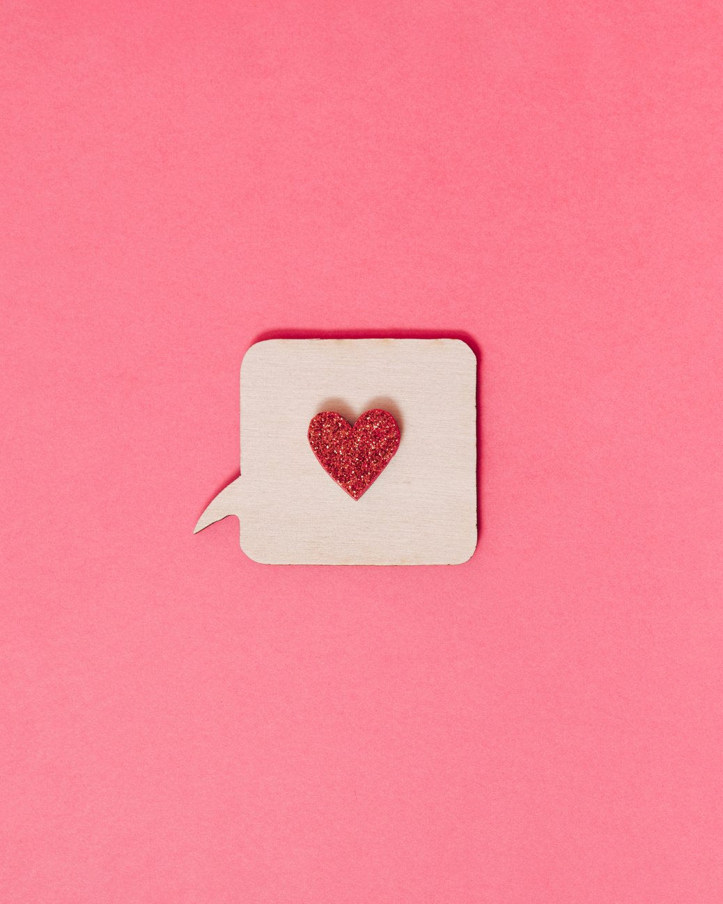 Red heart on conversation box as like icon on vibrant pink background. Minimal social media concept. Notification with like button to express emotions.